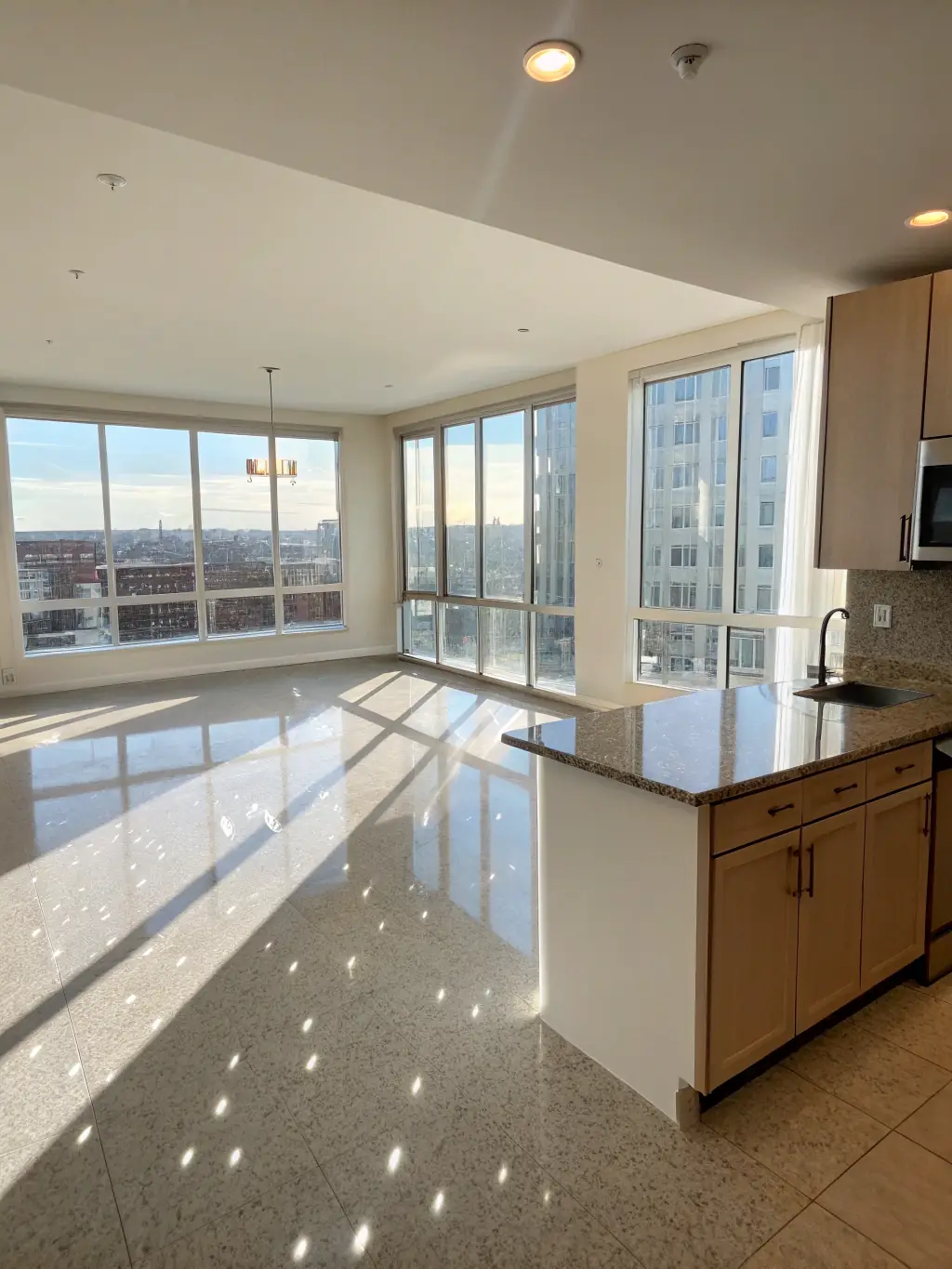 An empty apartment, freshly cleaned after a move-out service, with gleaming windows, clean baseboards, and spotless kitchen appliances.